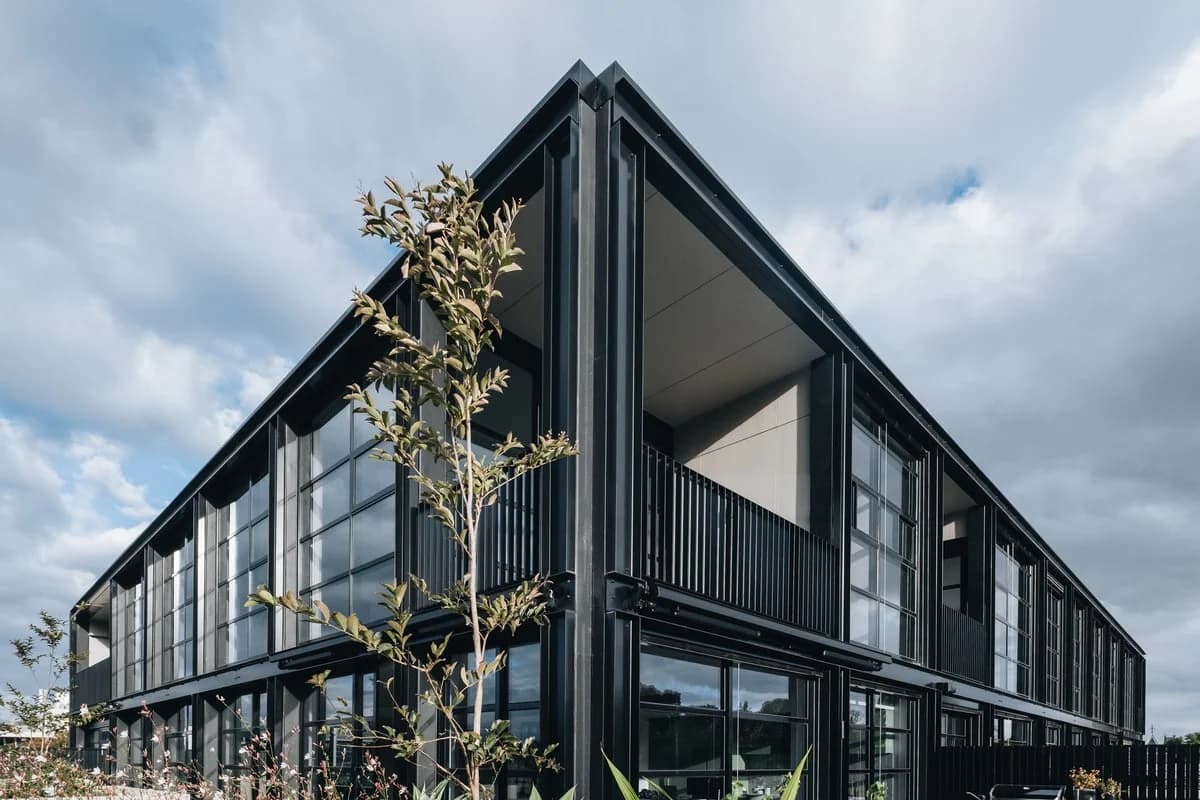 Modern two-story building with sleek design by CHT Architects, featuring large glass windows.