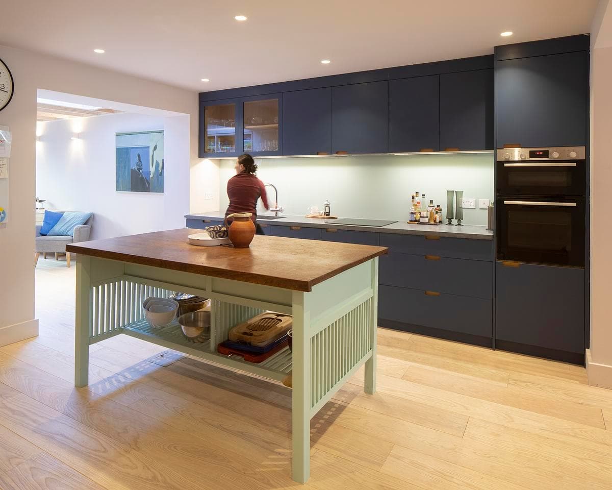 Wide view of the blue kitchen and dining area.