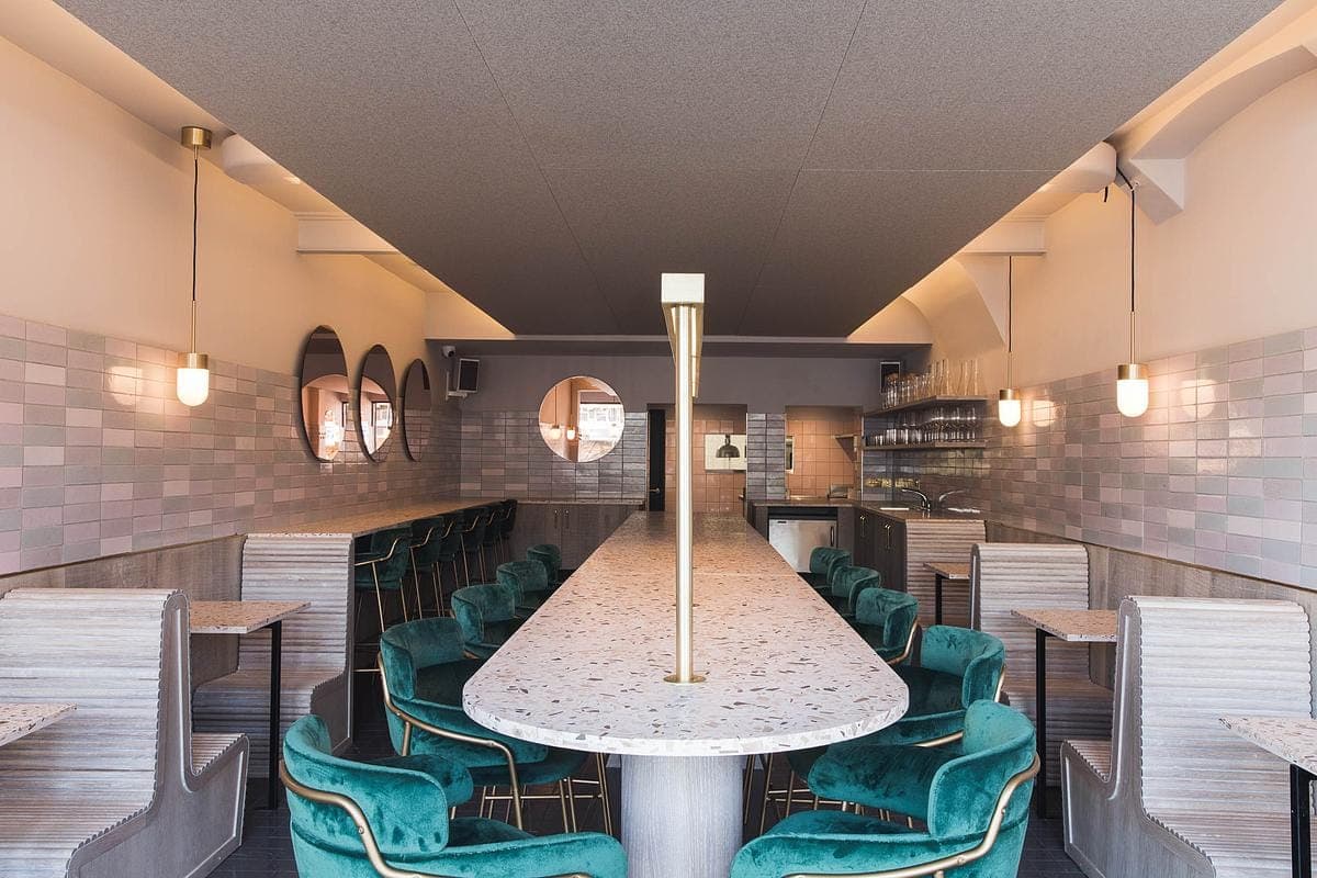 Dining room with a long table and green chairs.