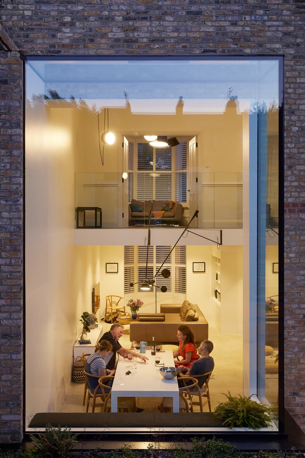 Modern two-story home with brick exterior, large window, and cozy family dining area.
