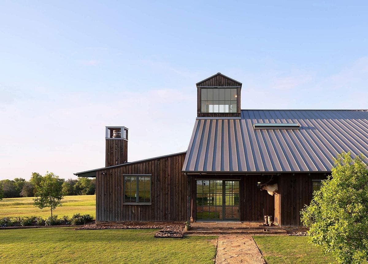 Stylish contemporary farmhouse blending modern design with rustic charm, set in a tranquil countryside.