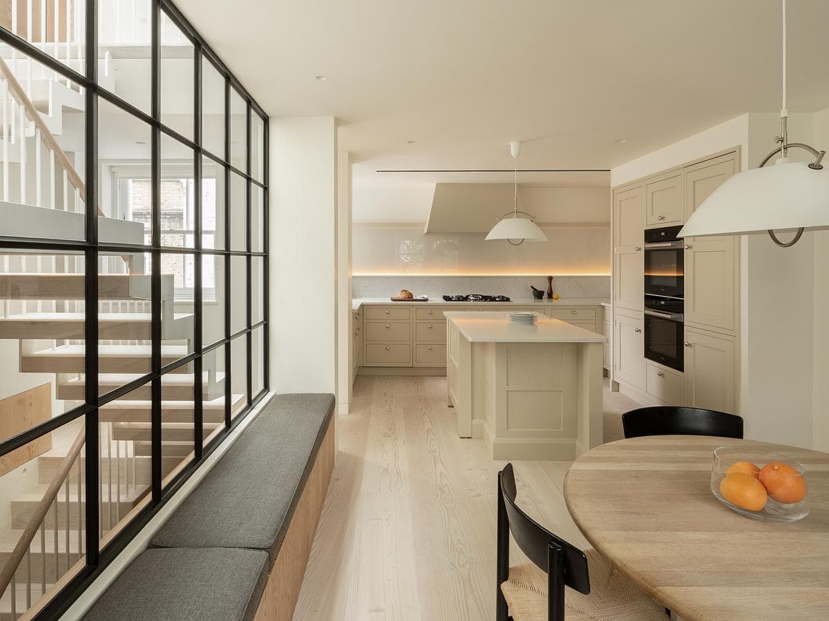 Contemporary kitchen with bright dining area, featuring natural light and stylish minimalist design.