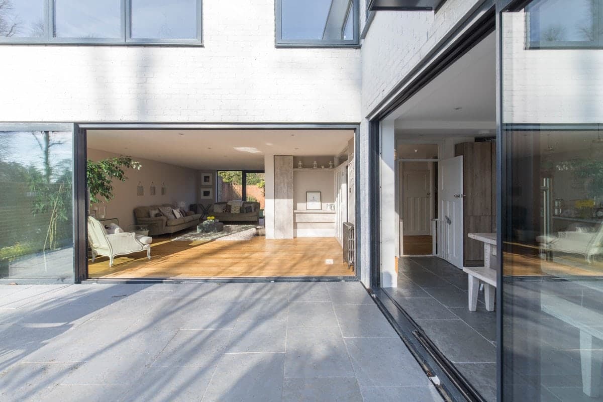 Modern open-concept living room with large glass doors and stylish patio area.