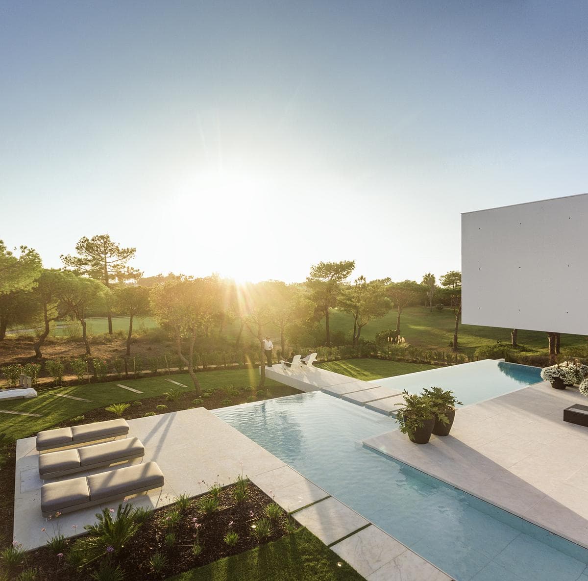 Tranquil outdoor pool with a white screen and scenic countryside backdrop for relaxation and gatherings.