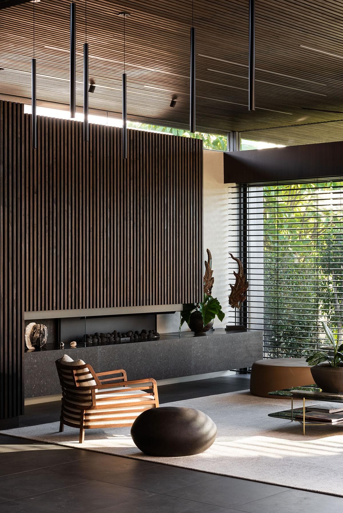 Lounge with a linear fireplace beneath the timber-slatted ceiling.