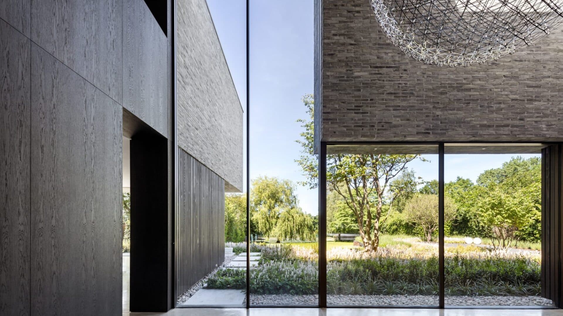 A pendant light and full-height glazing within the double-height space