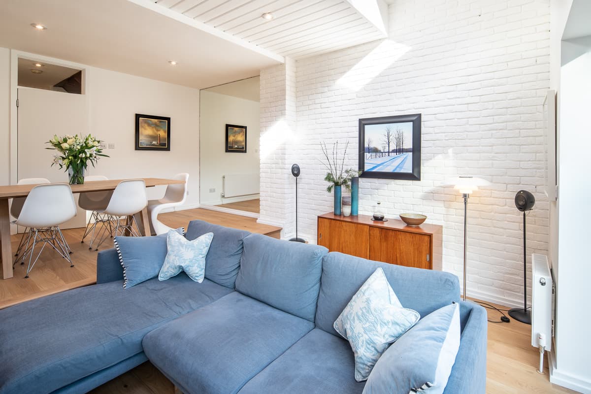 A blue sofa and white brickwork define the living area