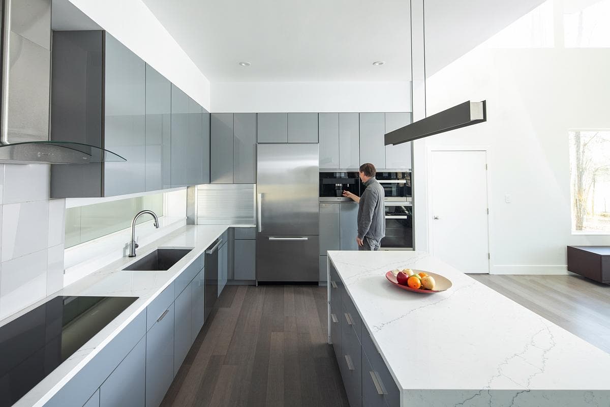 Kitchen with stainless-steel work surfaces and timber flooring