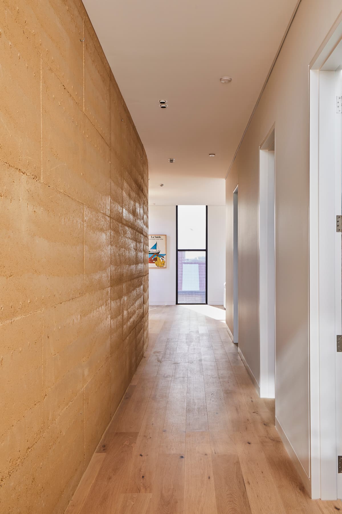 Rammed earth and timber define the passage through the house.