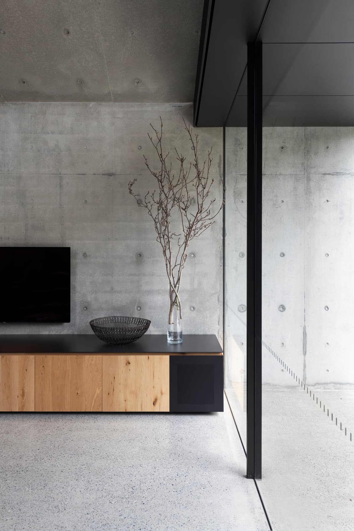 Concrete wall and timber hearth joinery