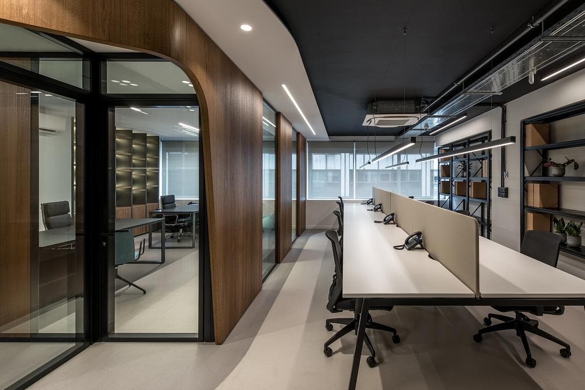 A long workstation runs alongside timber and glass partitions.
