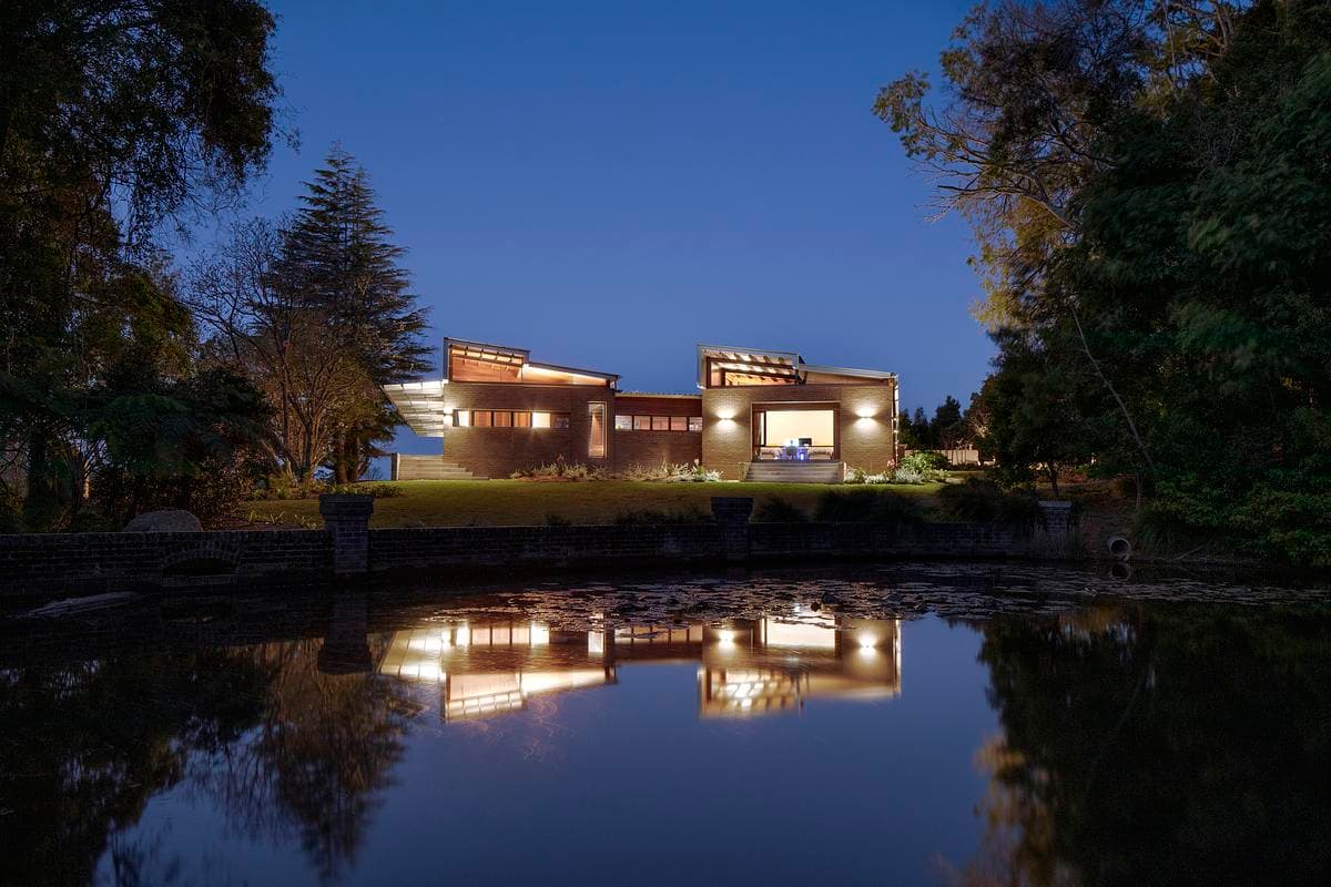 The farmhouse reflected in water at dusk.