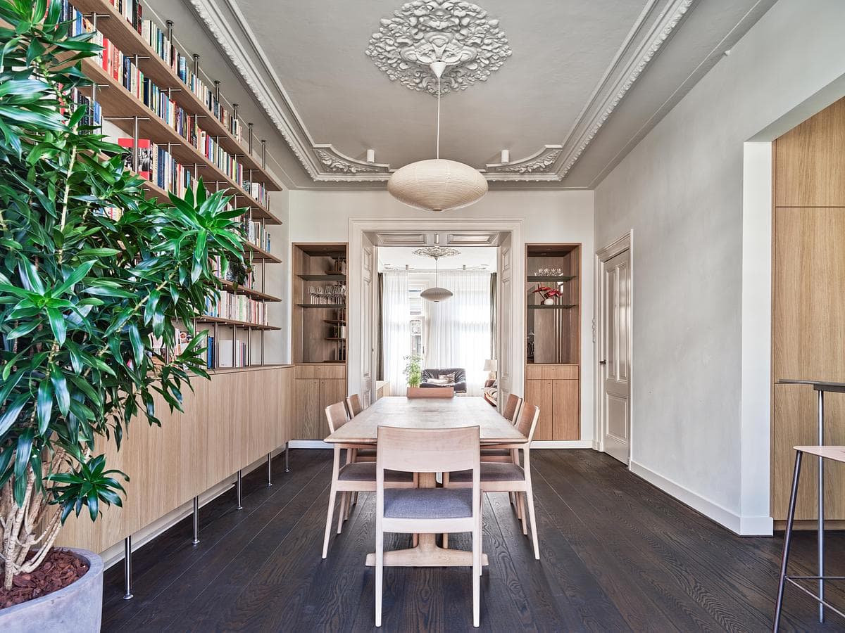 Dining room with full-height bookshelves and a paper pendant