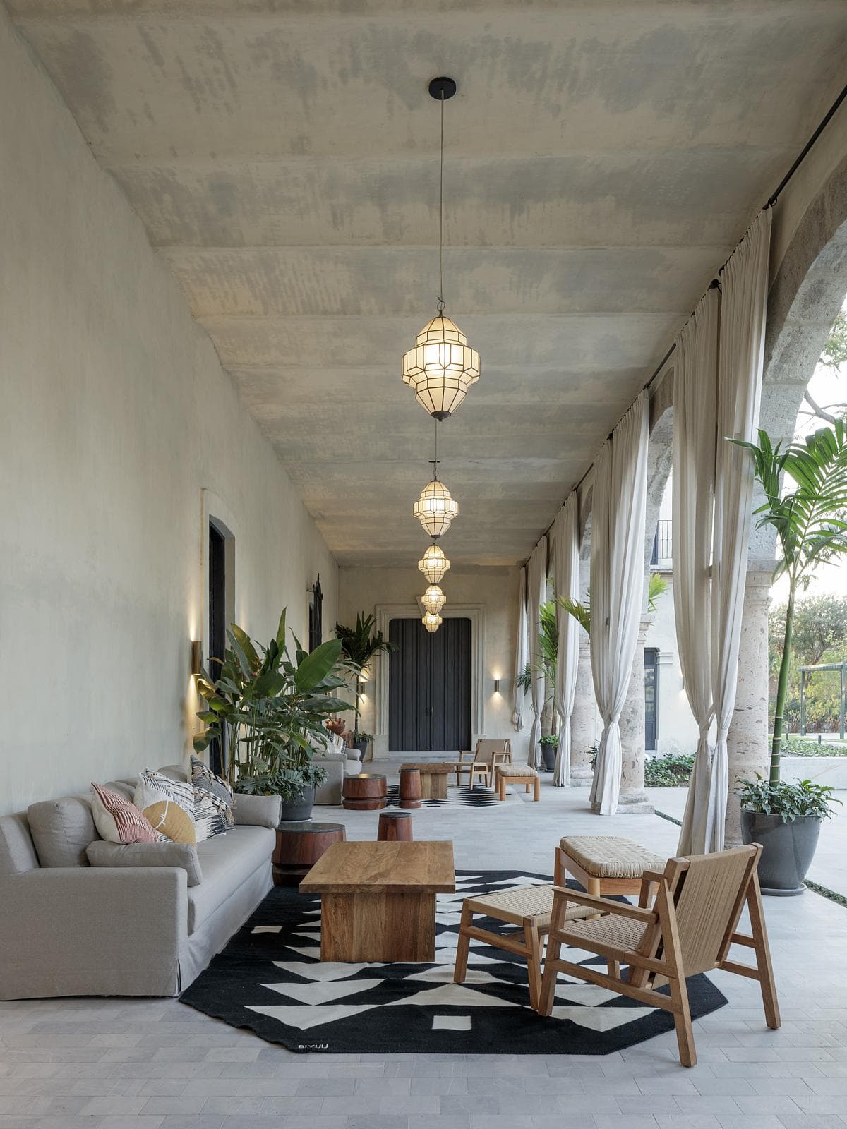Furnished portico with stone columns and long curtains