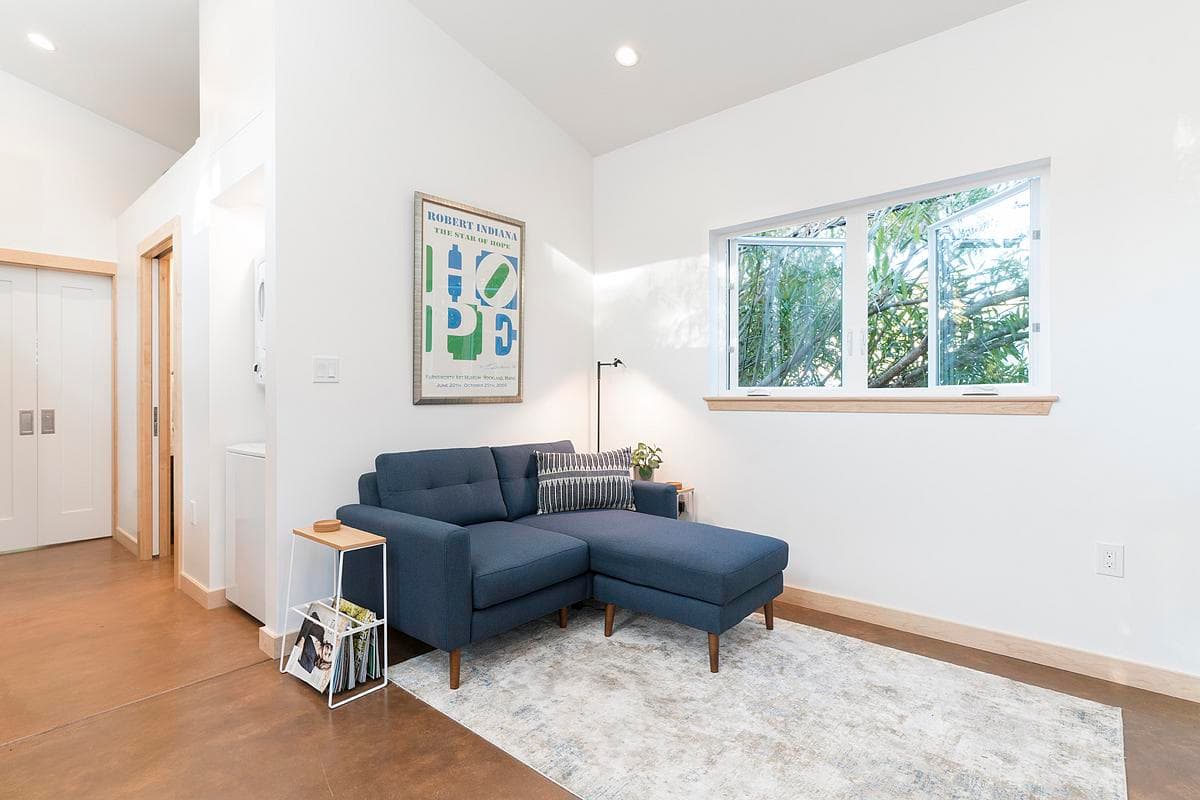 The living space opens towards a wide garden-facing window.