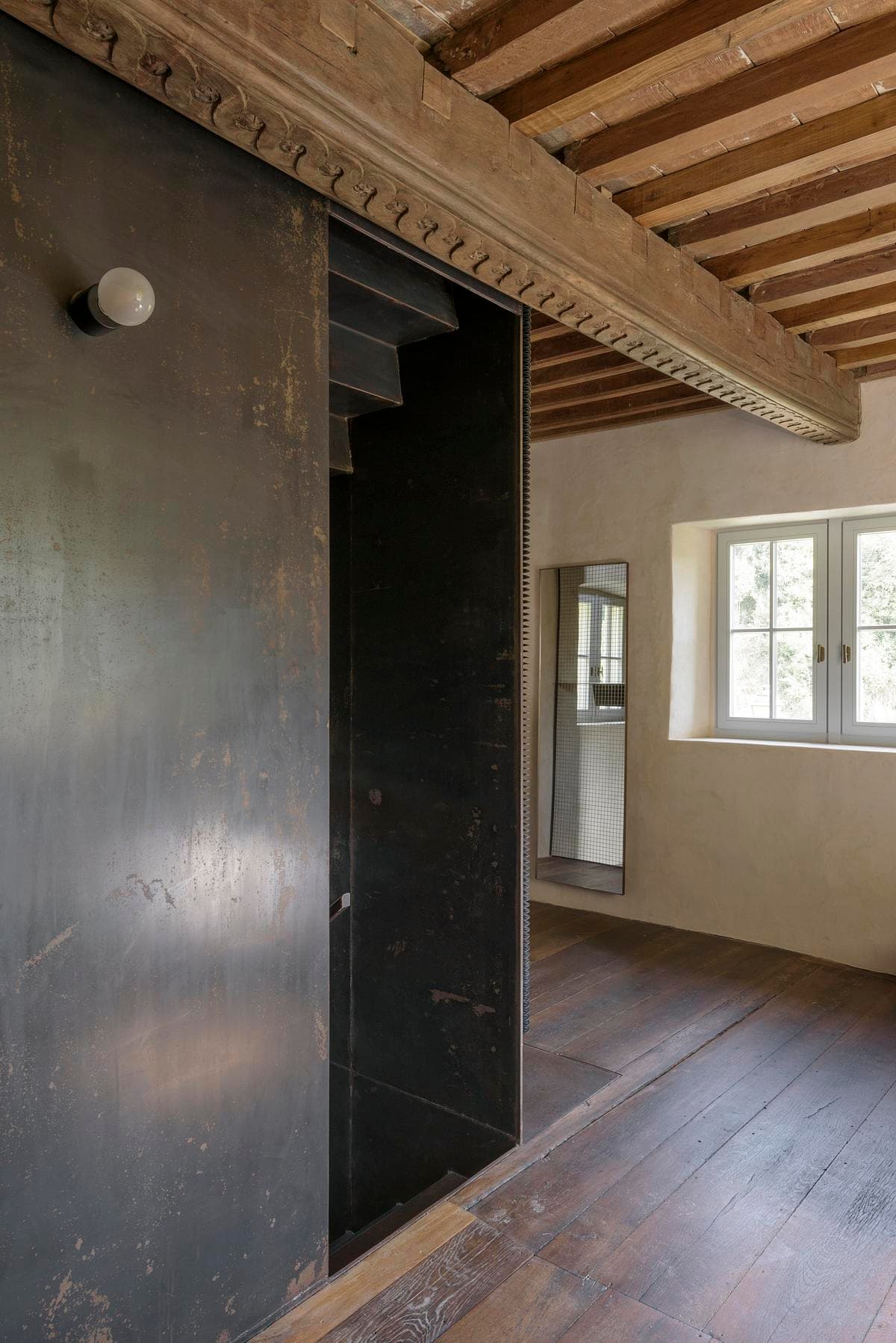 Steel core beside a bedroom with deep-set windows.