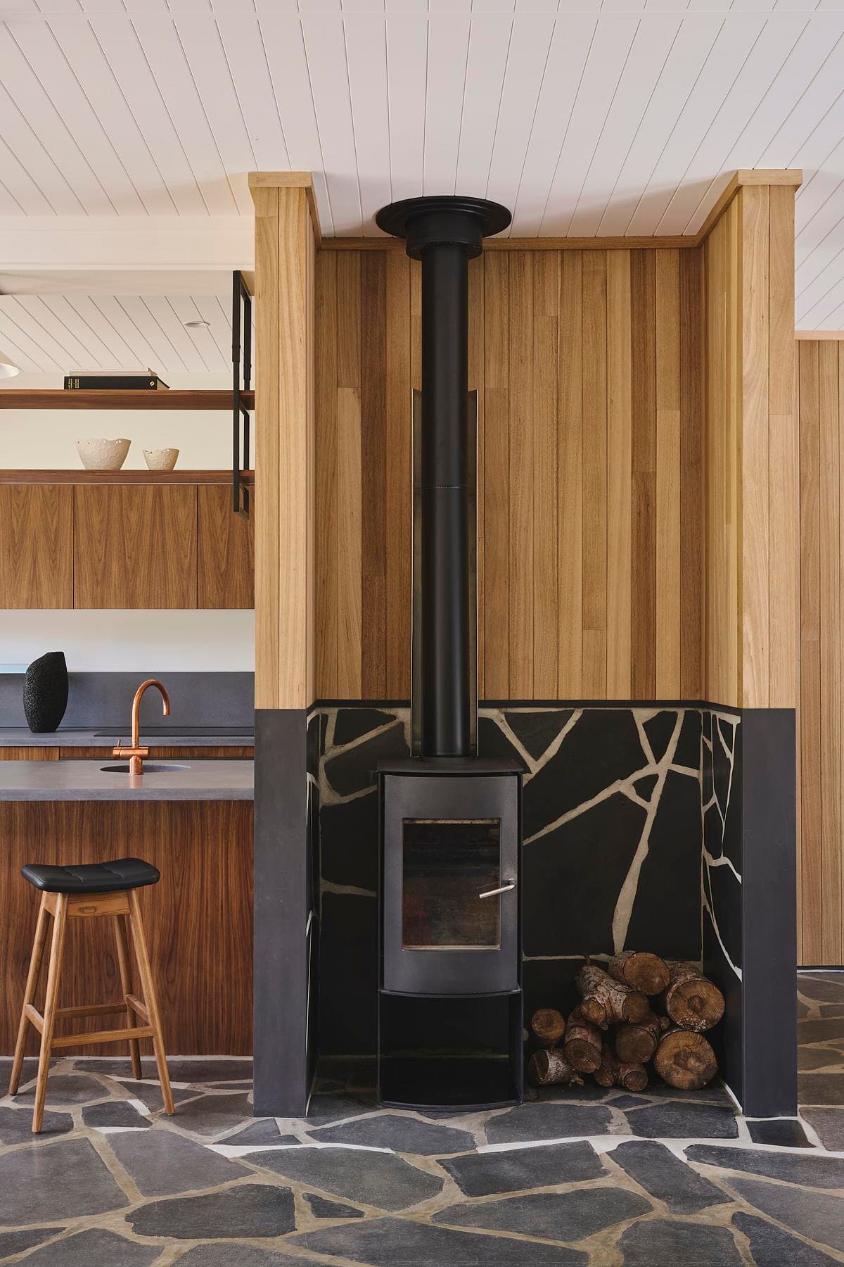 Freestanding stove beside timber wall cladding