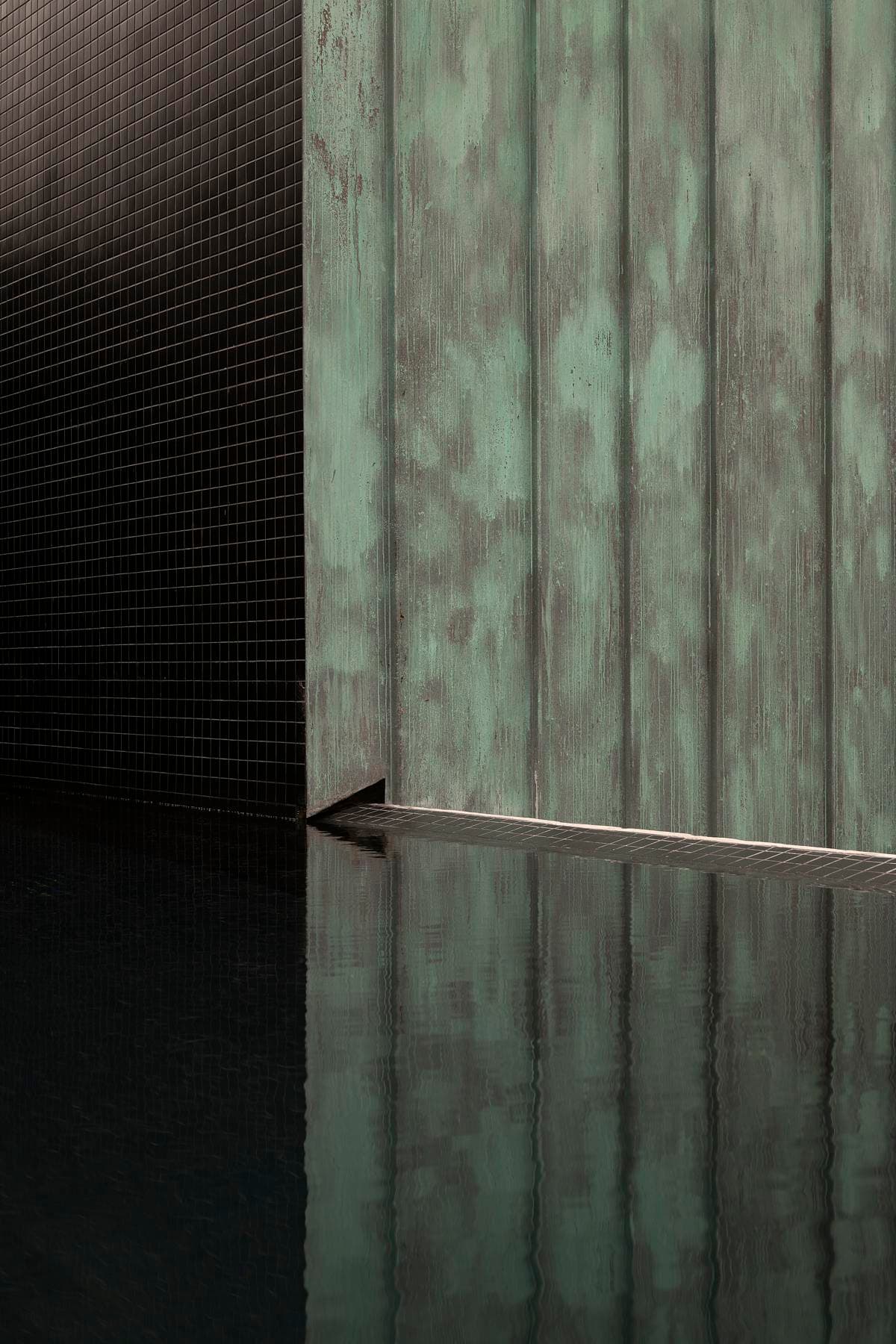 A close view of the patinated copper and a curved glazed opening.