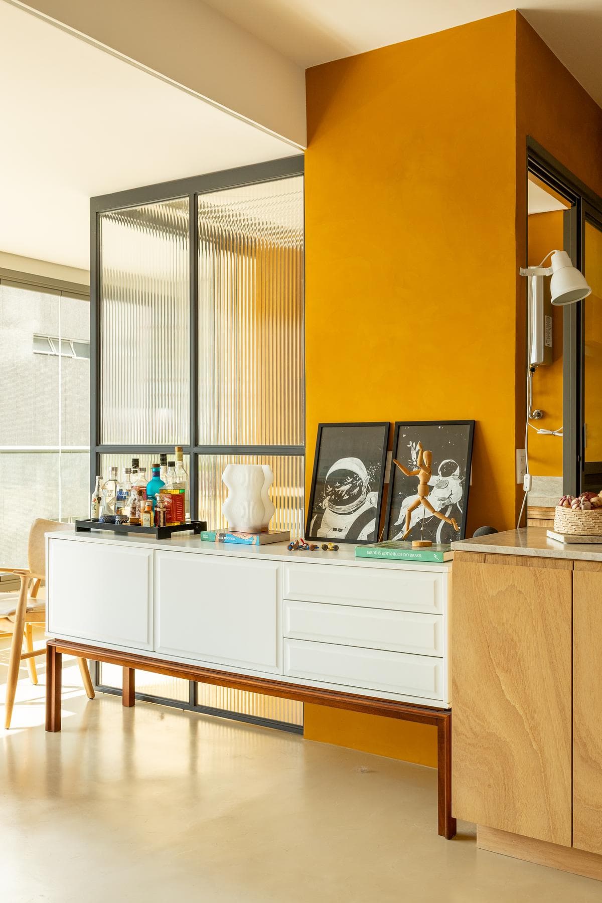 Yellow kitchen cabinetry meets a plywood sideboard.