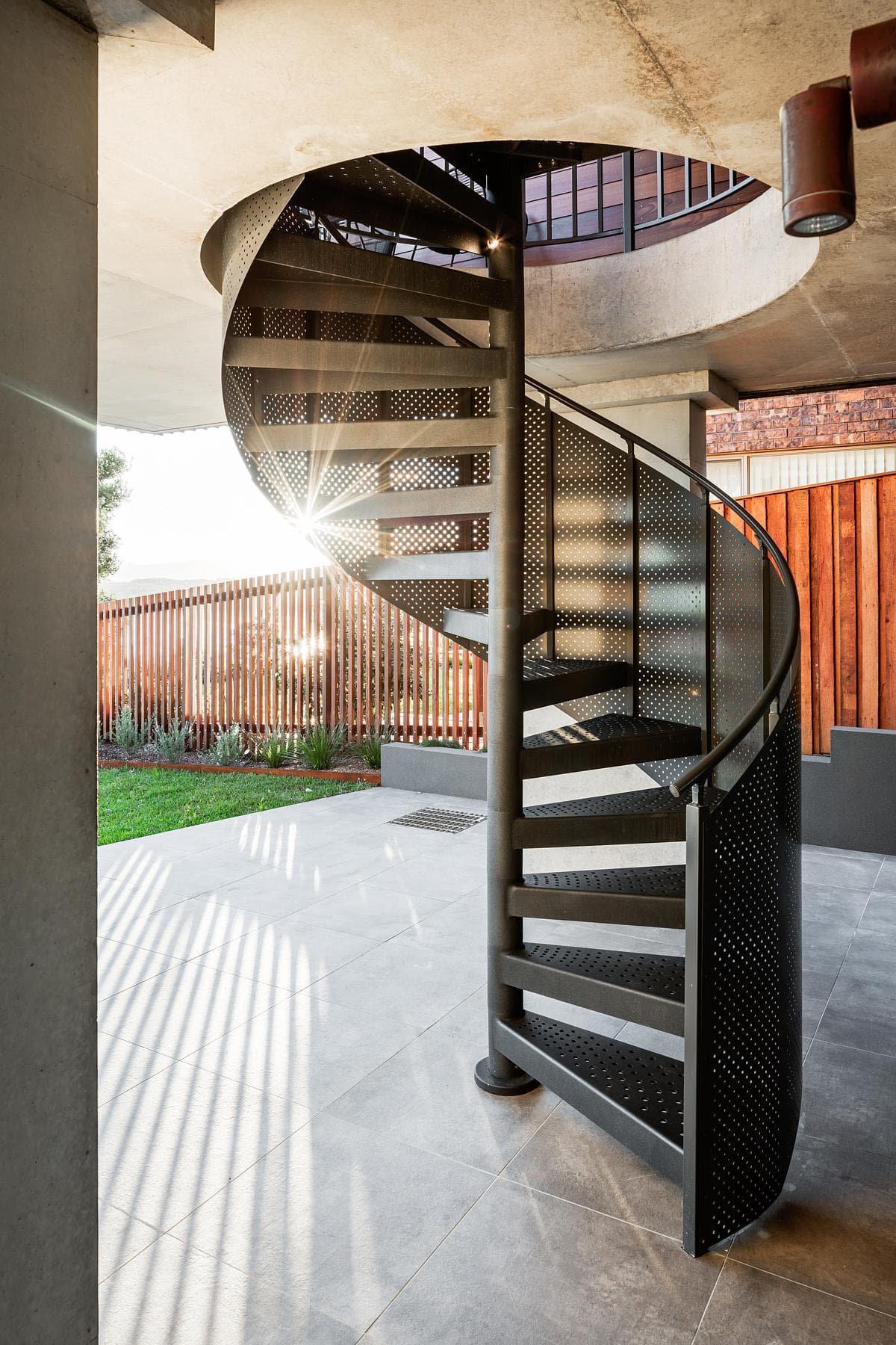 A spiral stair connects the levels beside the courtyard.
