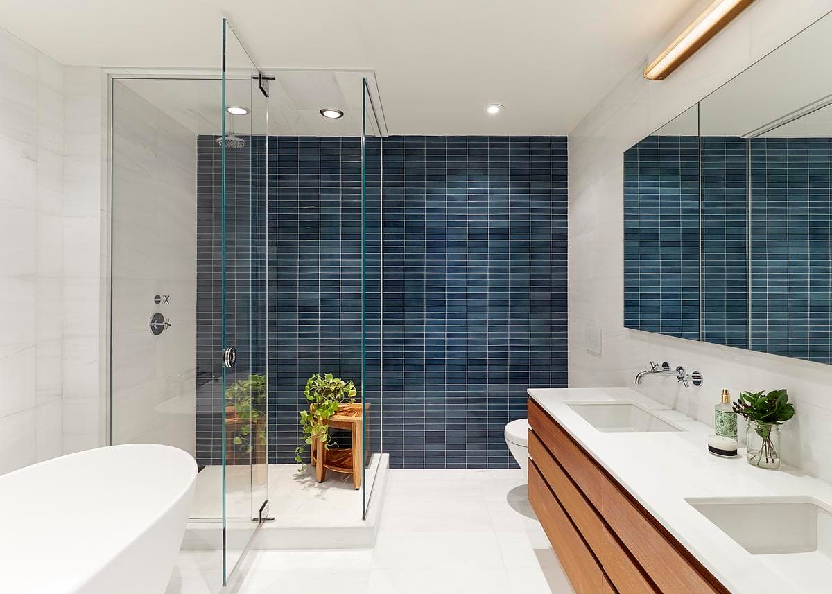 Deep-blue tiles and timber joinery continue into the bathroom.