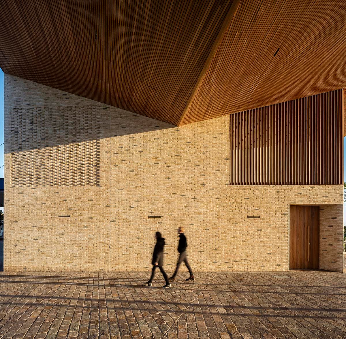 Brick walls and timber-lined roof framing the public passage