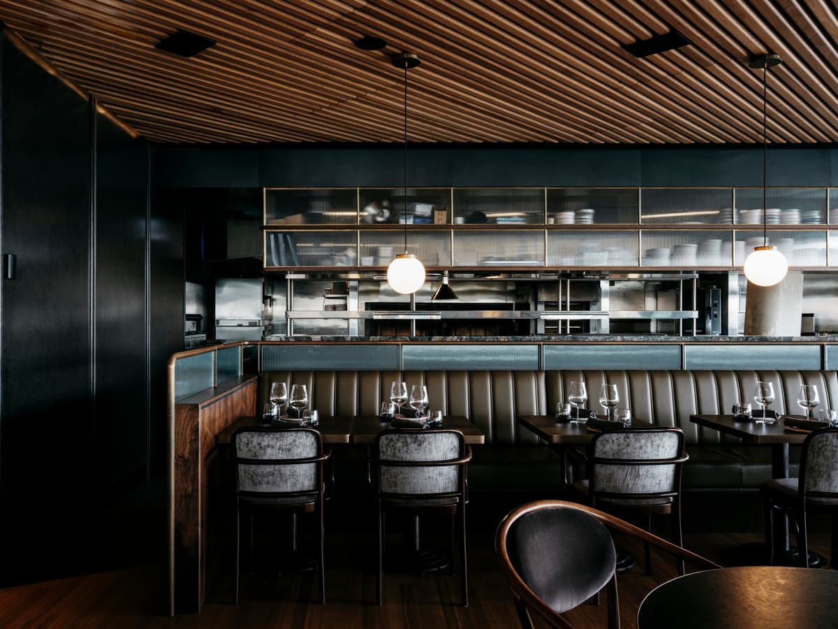 Dark seating and layered shelving give the bar a more enclosed atmosphere.