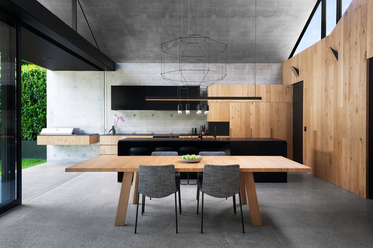 Kitchen and dining table between concrete and timber surfaces