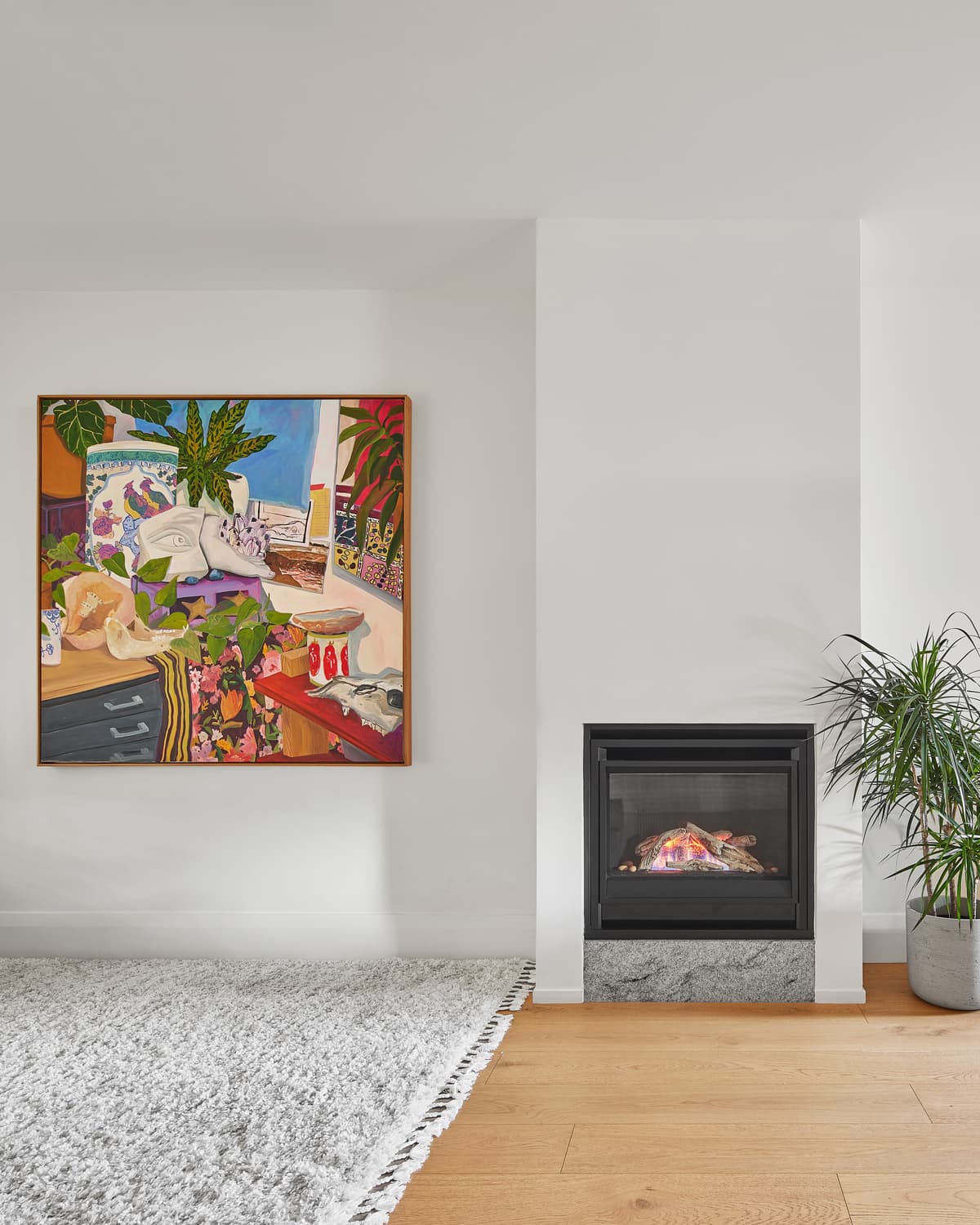 Artwork and a fireplace bring colour and warmth to the living room.