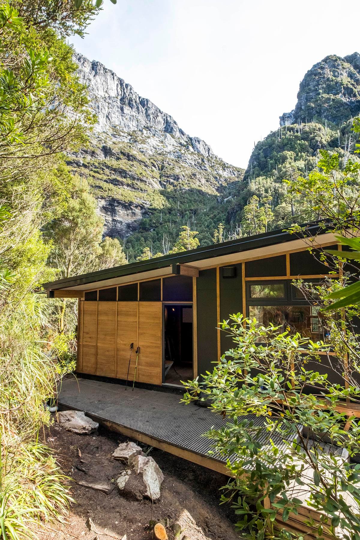 Timber walls and a sheltered path at the edge of the alpine forest.