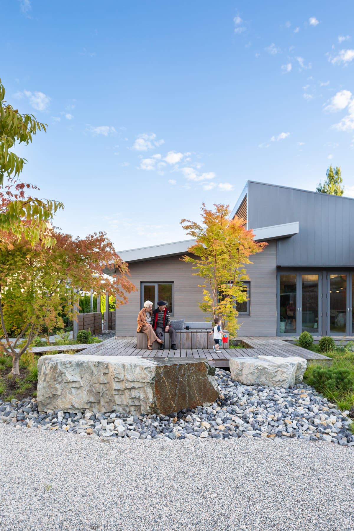 A planted rock garden and terrace sit beside the house.