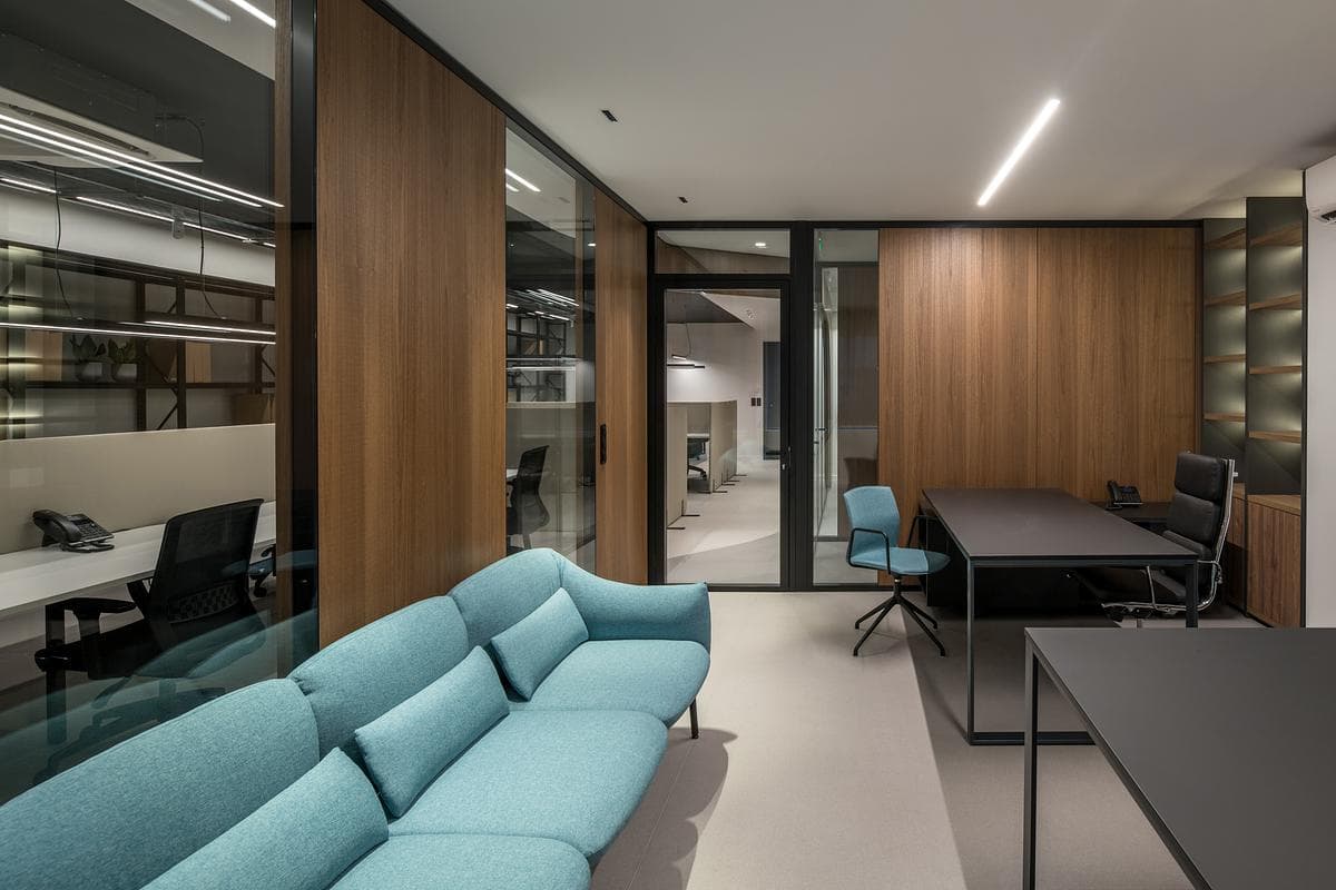 Blue seating creates a softer waiting area beside the glazed rooms.
