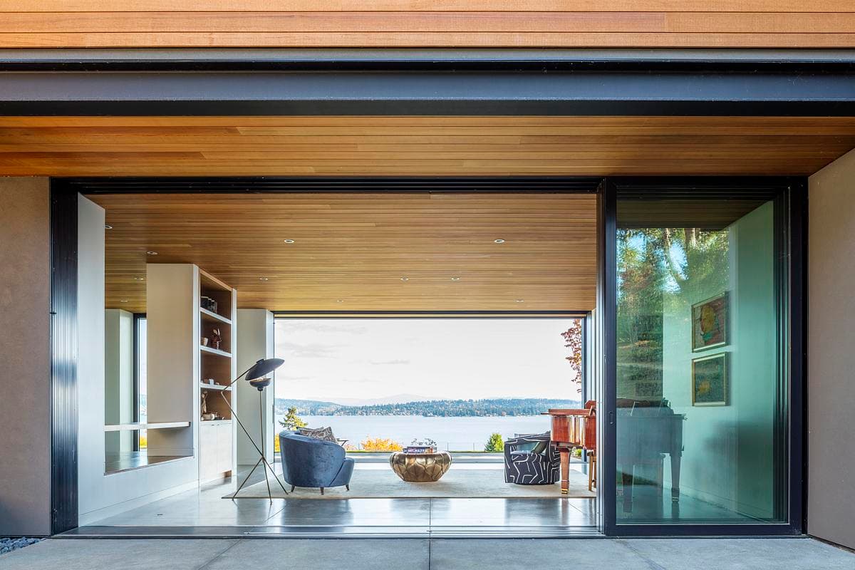 Open sliding doors align the living space with the lakeside patio