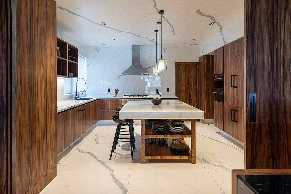 Marble-look porcelain runs across the kitchen floor, island and ceiling.
