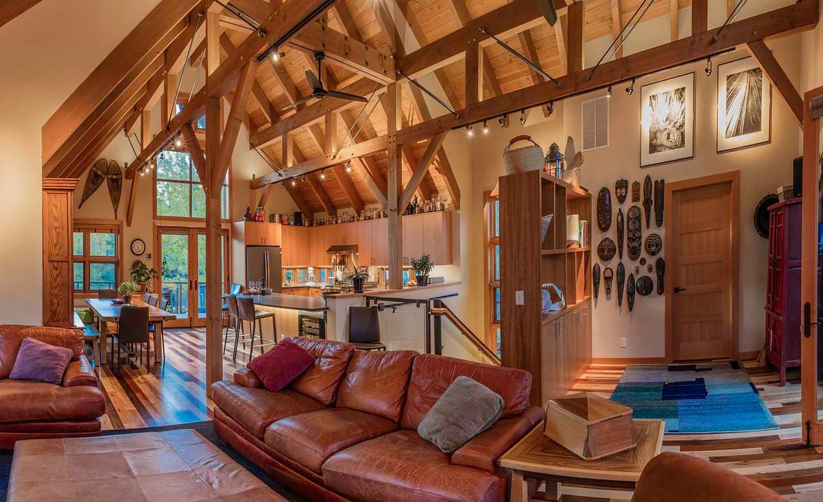 A fireplace and leather seating sit beneath the timber roof structure.