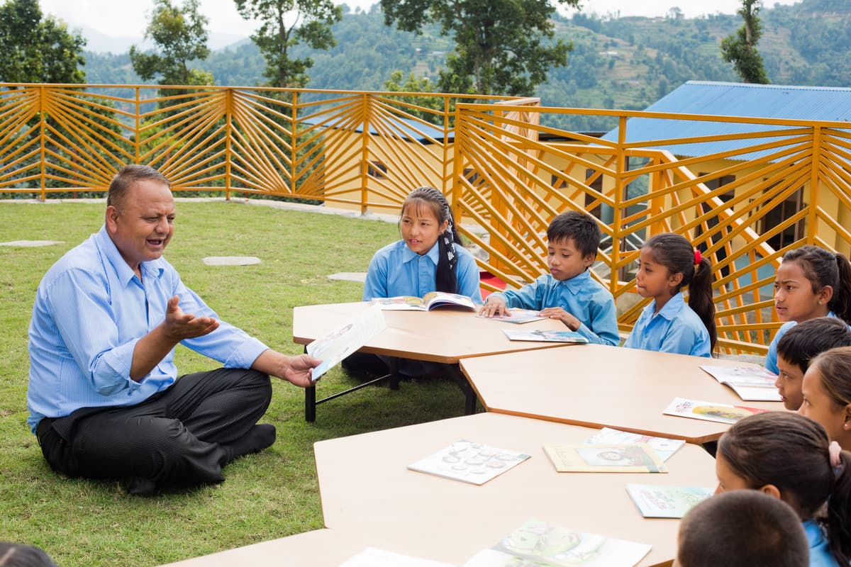 Trapezoidal desks are brought together for a lesson on the green roof.