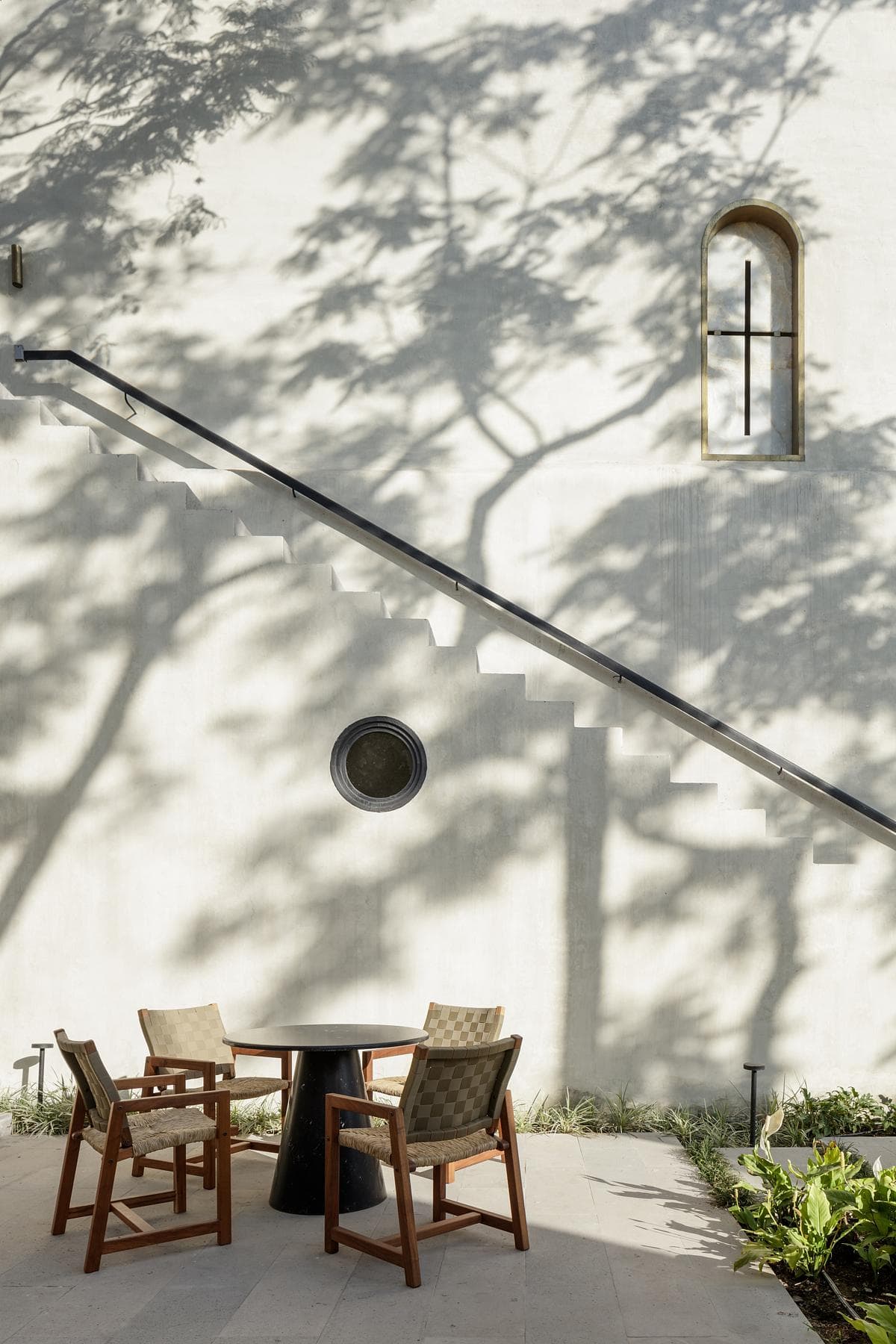 Courtyard seating beside a whitewashed wall and external stair.
