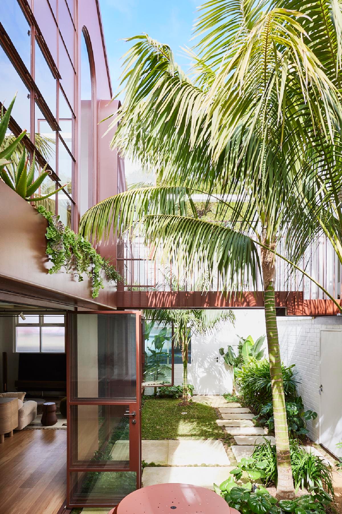 Central courtyard framed by red steel and palms