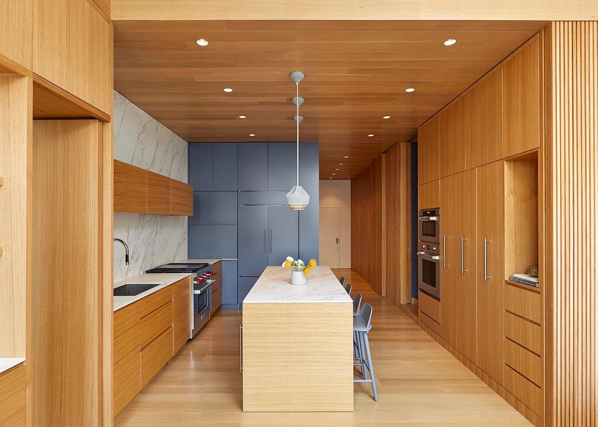 White oak joinery and deep-blue cabinetry define the kitchen.