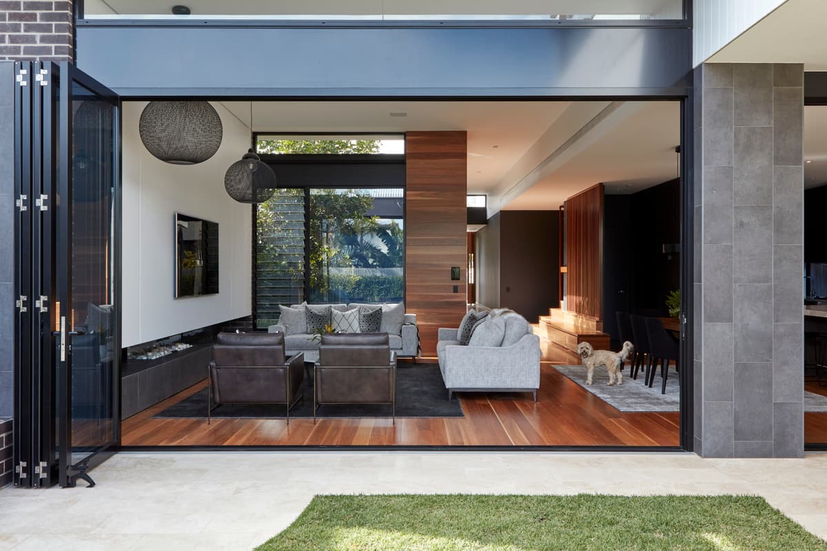 The living room opens towards the garden through a wide opening.