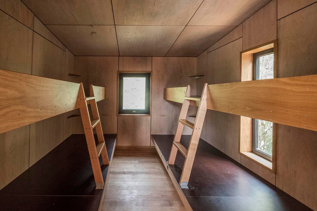 Timber bunks and narrow windows organise the sleeping space.