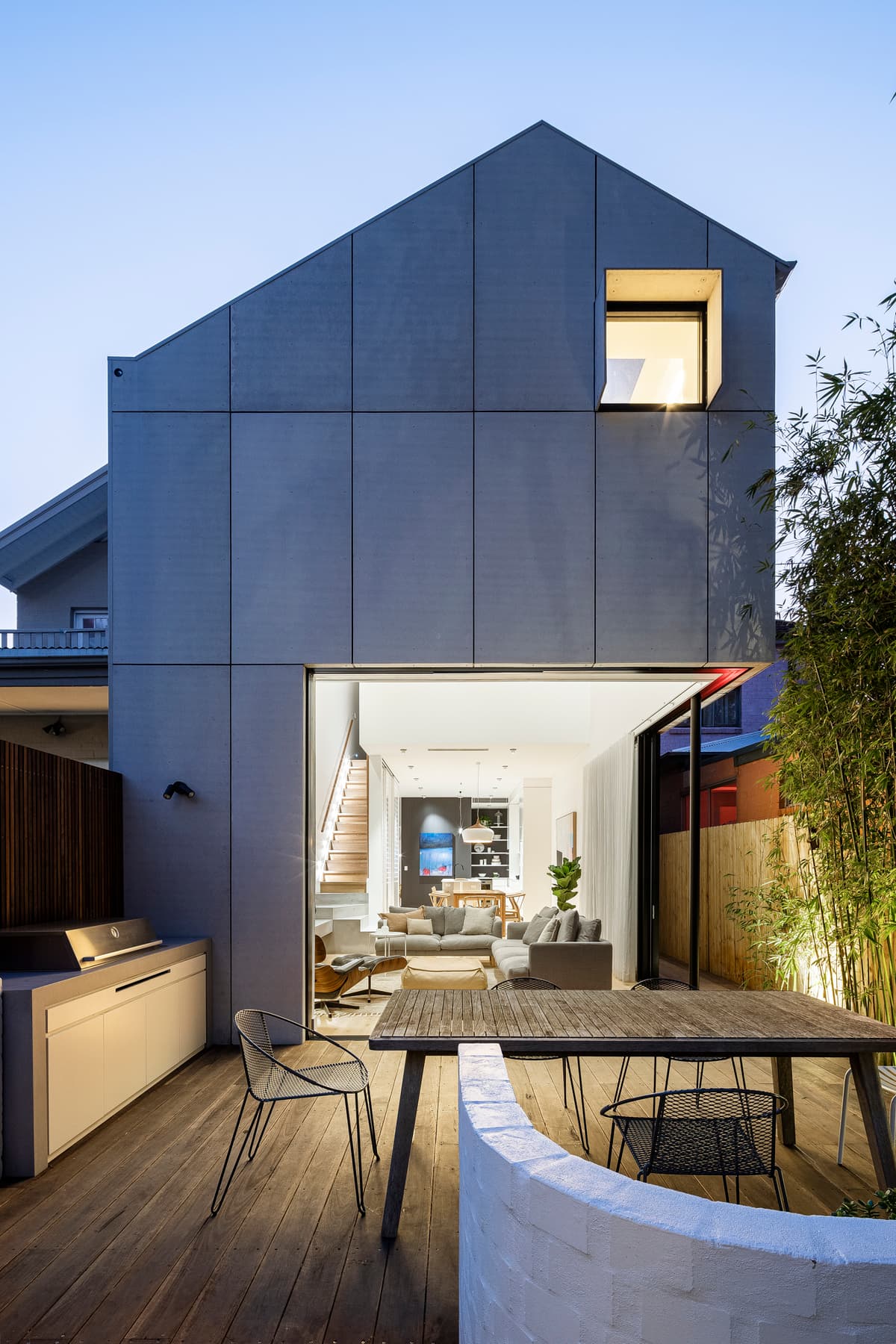 The rear addition opens onto a compact terrace and planted boundary.