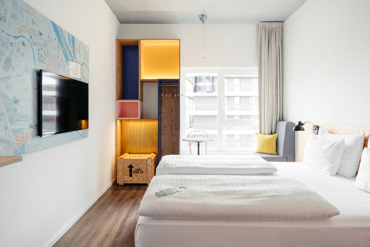 Timber joinery, a wall map and large window shape the guest room.