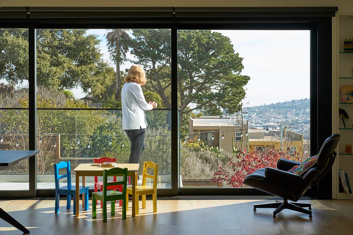 Living spaces look out through full-height glazing.