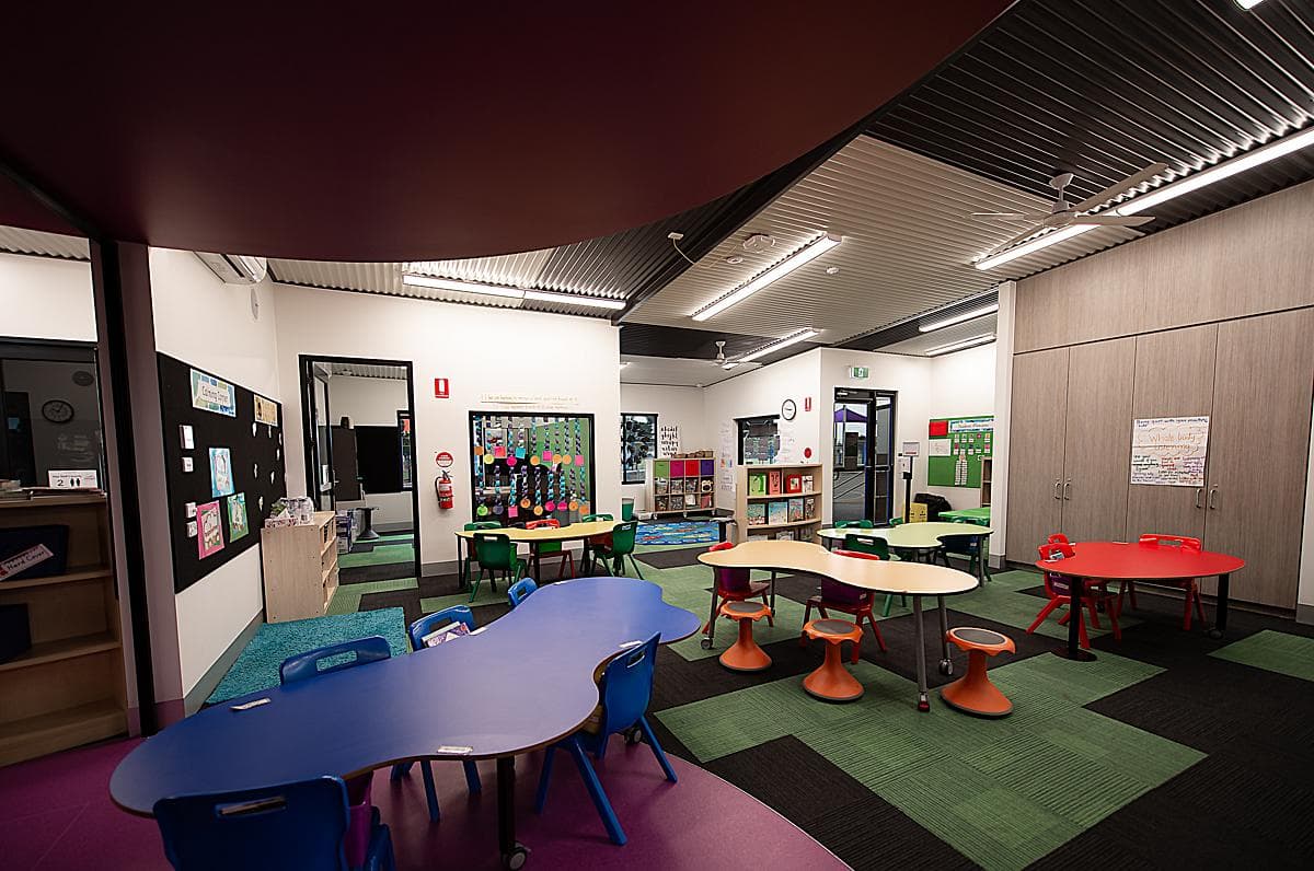 Shared learning area with coloured flooring and the purple breakout enclosure.