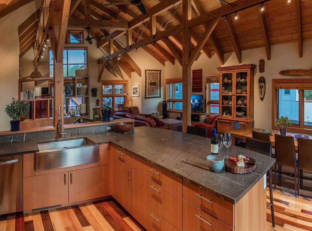 Exposed timber framing spans the open kitchen and living spaces.