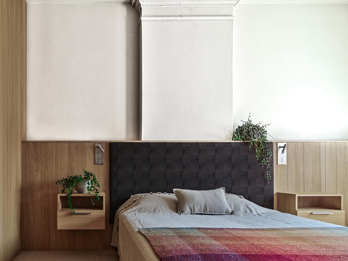 Bedroom with timber joinery and a padded headboard
