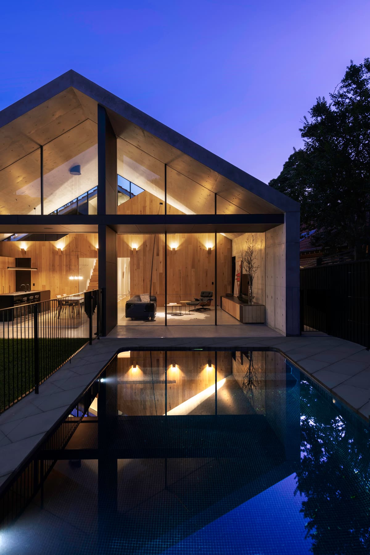 Glazed rear elevation and pool after dark