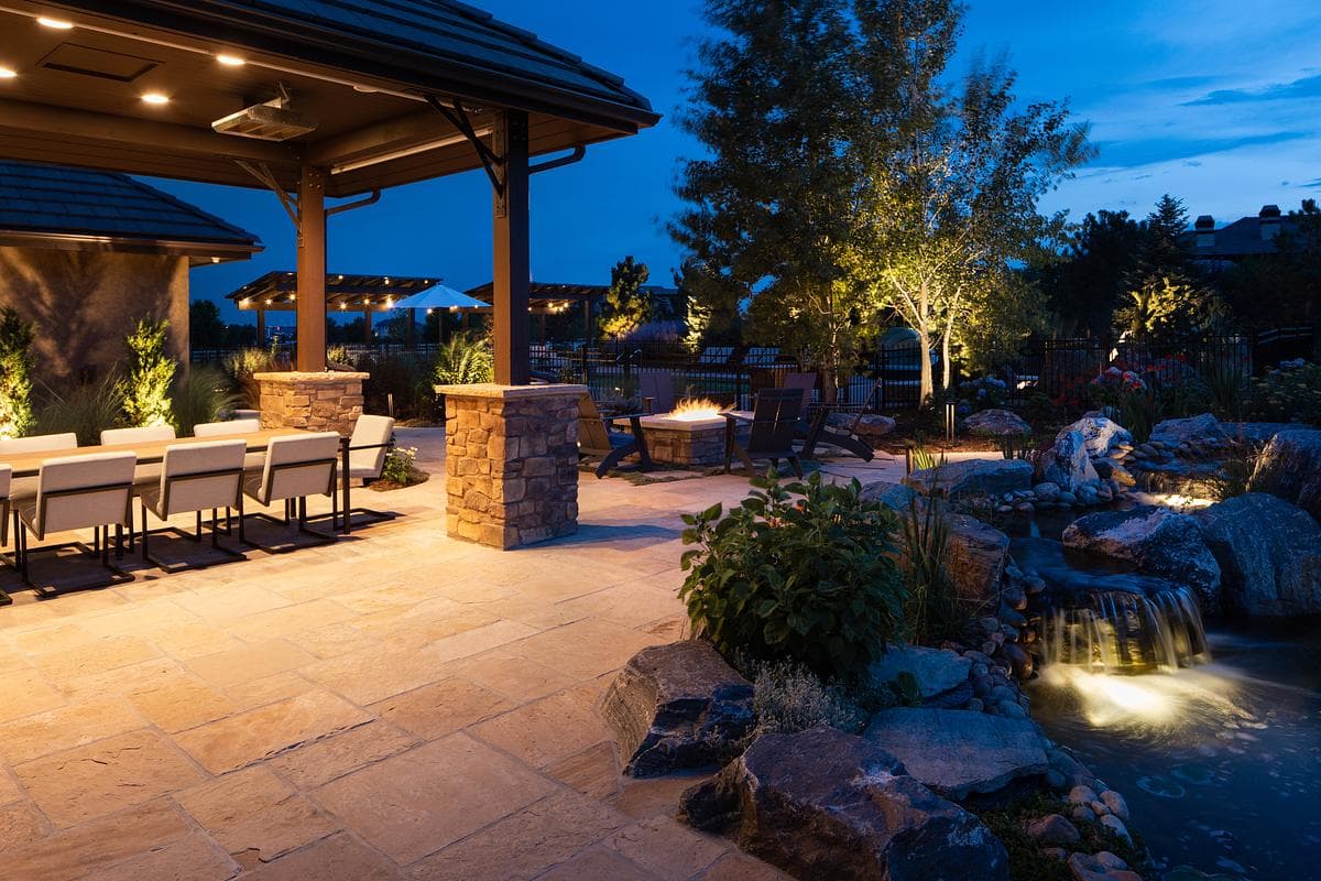 Covered outdoor kitchen and garden seating at dusk