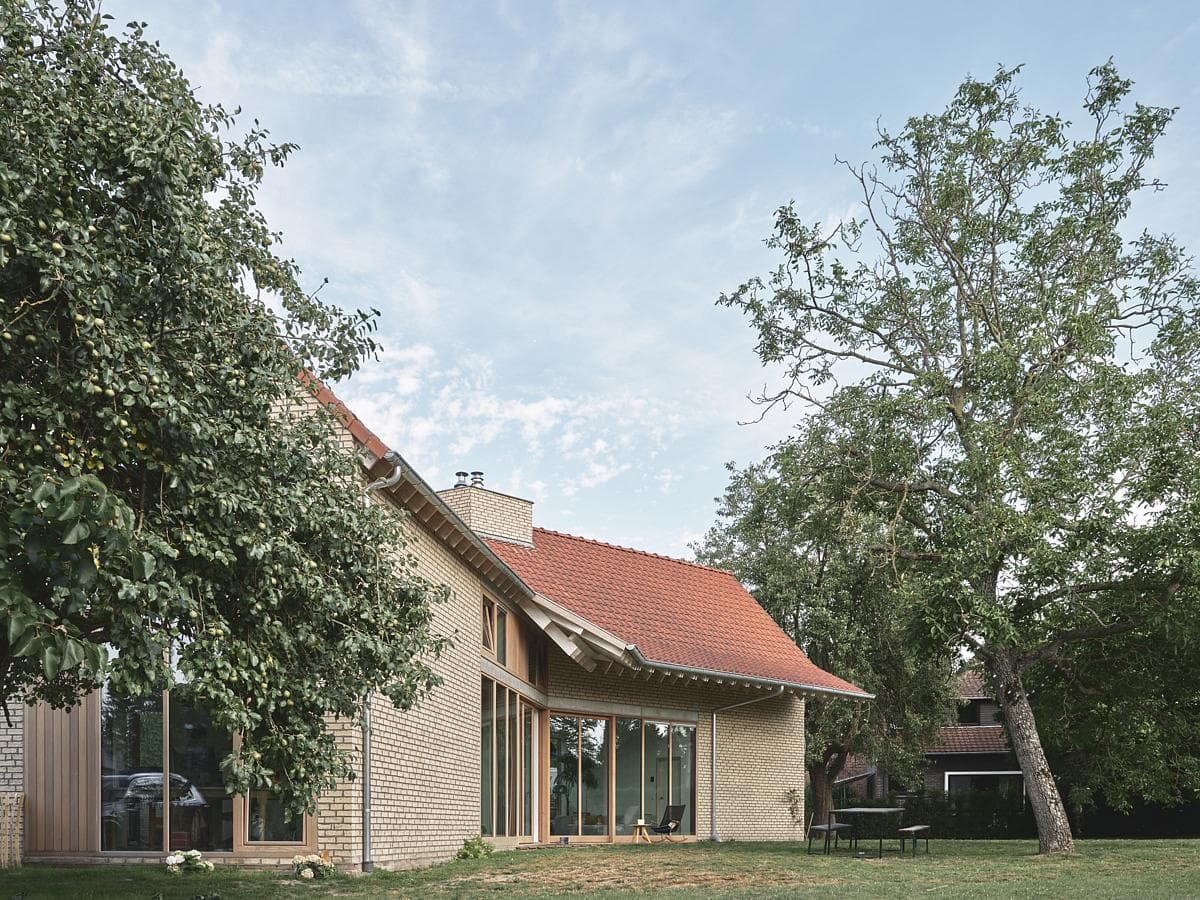 Brick elevations and a tiled roof set among the orchard trees
